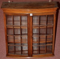 Lot 1066 - An Edwardian mahogany bowfront hanging cabinet,...