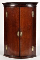 Lot 1081 - A George III mahogany bowfront hanging corner...