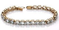 Lot 790 - A blue topaz line bracelet, each of the twenty-...