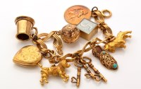 Lot 797 - A 9ct. yellow gold charm bracelet, the...