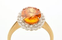 Lot 806 - An orange stone and diamond cluster ring, the...