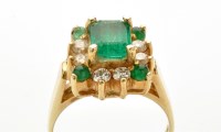 Lot 811 - An emerald and diamond cluster ring, the...