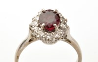 Lot 818 - A ruby and diamond cluster ring, the oval...