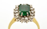 Lot 823 - An emerald and diamond cluster ring, the...