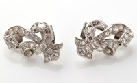 Lot 842 - A pair of diamond earrings, of stylized...