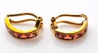 Lot 844 - A pair of garnet ear clips, each of half hoop...