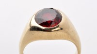 Lot 855 - A synthetic ruby ring, the oval facet cut...