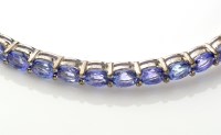 Lot 742 - A tanzanite bangle, with fifteen oval facet...