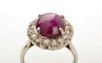 Lot 745 - A star ruby and white stone cluster ring, the...