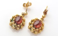 Lot 773 - A pair of yellow metal and red stone drop...