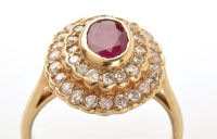 Lot 782 - A ruby and diamond cluster ring, the oval...