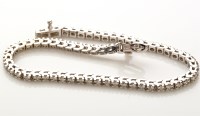 Lot 802 - A diamond set line bracelet, sixty-one...