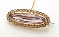 Lot 825 - An amethyst and seed pearl brooch, the oval...