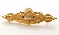 Lot 827 - A diamond and red stone set yellow metal...