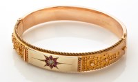 Lot 833 - A 9ct. yellow gold Etruscan style bangle,...