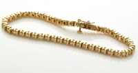 Lot 838 - A diamond and yellow metal tennis bracelet,...