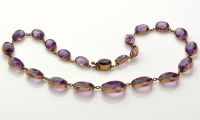 Lot 850 - An amethyst necklace, set with twenty-two oval...