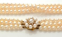 Lot 879 - A triple row cultured pearl necklace, strung...