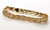 Lot 880 - A 9ct. yellow gold twist pattern bracelet,...