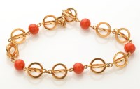 Lot 887 - A gold and coral bracelet, the five coral...