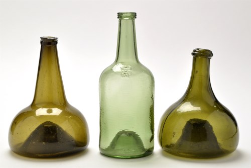 Lot 1029 - Two green glass onion shaped bottles, the...