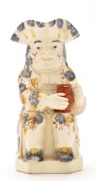 Lot 1099 - Mottled creamware character jug, the seated...