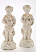 Lot 1183 - Pair of porcelain figures of putti, scantly...