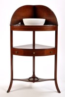 Lot 1384 - A late Georgian mahogany corner wash stand,...