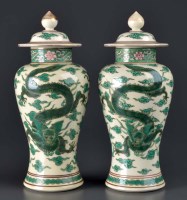 Lot 1004 - A pair of covered baluster vases, painted with...