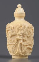 Lot 1034 - A carved ivory snuff bottle, carved with twin...