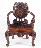 Lot 1058 - An Oriental carved hardwood armchair, the back...