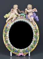 Lot 1099 - Meissen: an oval mirror, the moulded frame...