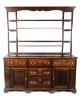 Lot 1298 - A Georgian oak dresser, the three-tier open...