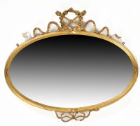 Lot 1320 - A gilt gesso oval bevelled wall mirror in the...