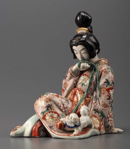 Lot 72 - A Satsuma figure of a seated Geisha holding...