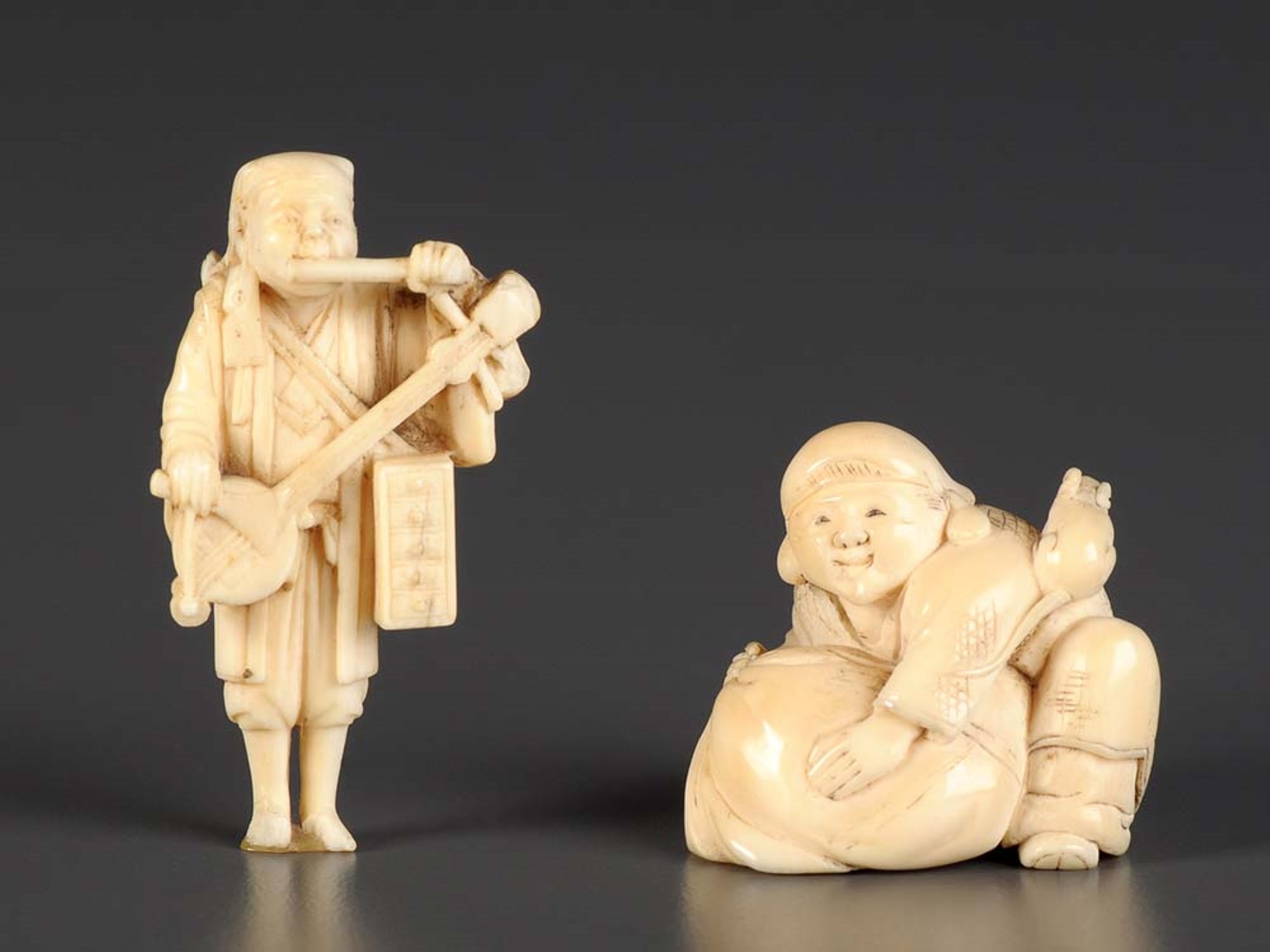 Lot 80 - A carved ivory netsuke of a man playing
