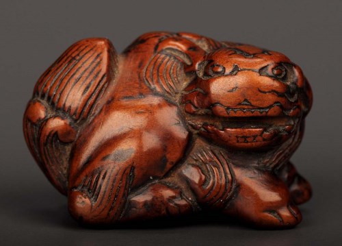 Lot 84 - A carved boxwood netsuke of a shishi lion,...