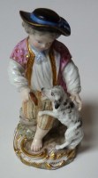 Lot 128 - Meissen: a figure of a boy giving his dog a...