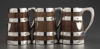 Lot 555 - Three coopered oak barrel-pattern tankards, by...