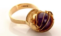 Lot 865 - A gold and amethyst ring, c.1970, the polished...