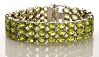 Lot 896 - A peridot bracelet, the three rows of...