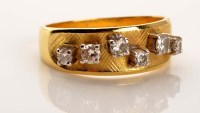 Lot 917 - A diamond and gold ring, the broad textured...