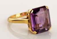 Lot 920 - An amethyst dress ring, the emerald cut...