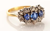 Lot 947 - A sapphire and diamond cluster ring, the three...