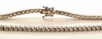 Lot 971 - A diamond line bracelet, the uniform row of...