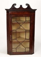 Lot 1336 - A Georgian mahogany corner cupboard, the swan...