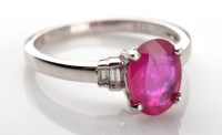 Lot 1041 - A ruby and diamond ring, the oval mixed cut...