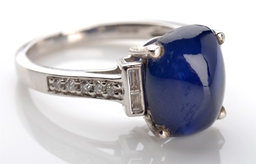Lot 1042 - A sapphire and diamond ring, the oval cabochon...