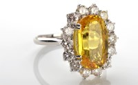 Lot 1045 - A yellow sapphire and diamond cluster ring,...
