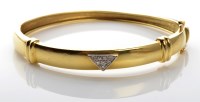 Lot 1061 - A diamond and yellow metal bangle, the upper...